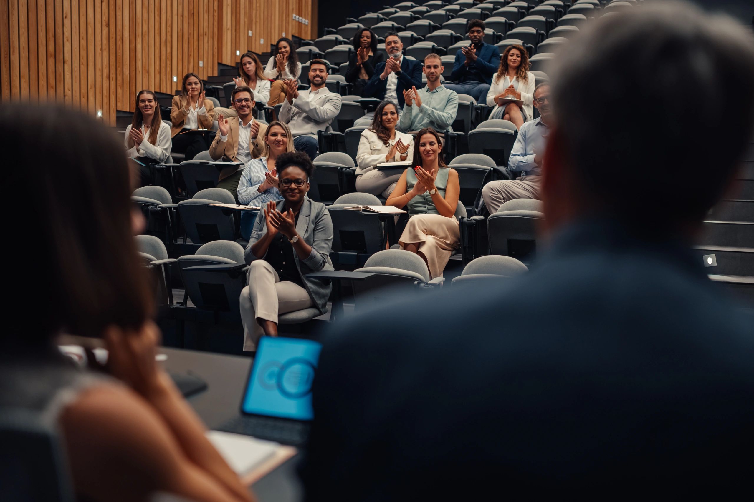 Conference audience applauding a presentation in a modern lecture hall